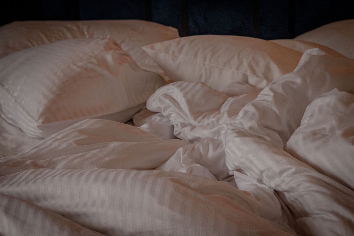 Ambiente ilustrativo: ropa de cama blanca iluminada por luz natural
